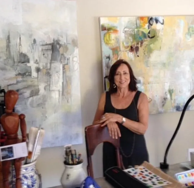 Michele Zuzalek in her studio between two abstract paintings